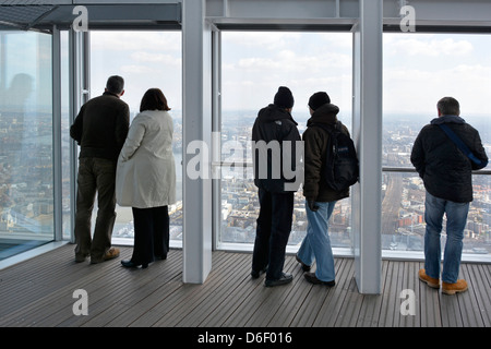 In alto nello Shard, punto di riferimento, grattacielo interno, piattaforma di osservazione pubblica, vista sul retro delle persone che ammirano il paesaggio londinese Southwark Londra Inghilterra Regno Unito Foto Stock