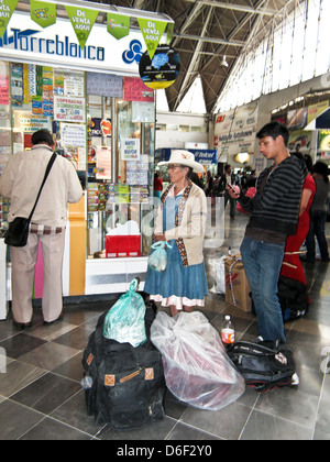 Anziana signora messicana in abito da casa sormontato da elegante sombrero bianco in piedi con effetti personali in Puebla first class terminal degli autobus Foto Stock