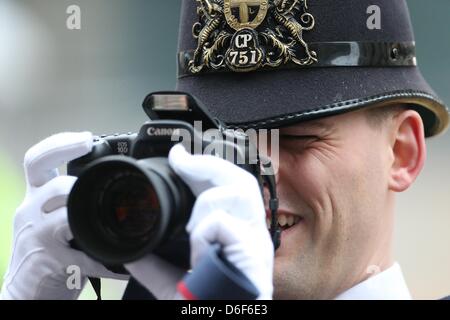 Londra, Regno Unito. Il 17 aprile, 2013. Un poliziotto di Londra scatta una fotografia di un membro del pubblico in mezzo alla folla a Margaret Thatcher i funerali presso la Cattedrale di San Paolo a Londra centrale. Dignitari di tutto il mondo uniti la Regina Elisabetta II e del Principe Filippo , Duca di Edimburgo come il Regno Unito paga il tributo a ex Primo ministro Thatcher Baronessa Thatcher durante un funerale cerimoniali con gli onori militari presso la Cattedrale di St Paul. Signora Thatcher, che morì la settimana scorsa è stata la prima donna britannica il Primo Ministro e servito dal 1979 al 1990. Foto Stock