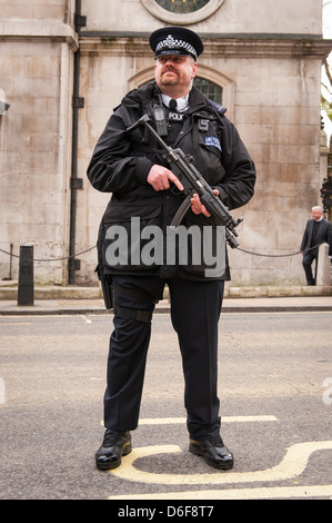 London Aldwych Strand Baronessa Maggie Margaret Thatcher funerale big tall armati poliziotto barbuto in uniforme con la mitragliatrice Foto Stock