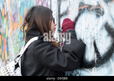 Turisti asiatici scritta sul muro di Berlino presso la Galleria Eastside Foto Stock