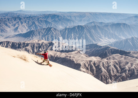 Sandboarding sul Cerro Blanco, una duna di sabbia sulla cima di una montagna con 2078 metri di altezza. Foto Stock