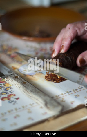 La donna per affettare il Chorizo Stick Foto Stock