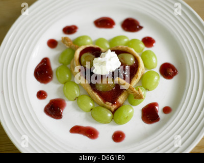 Pasta sfoglia con cuore plumb e uva - con ricetta / fase shot Foto Stock