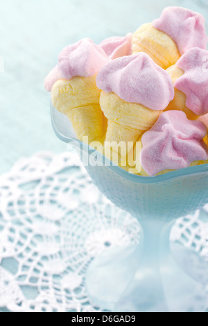 Rosa zuccherino marshmallows conformato come il gelato in una ciotola sul blu vintage sfondo di legno Foto Stock