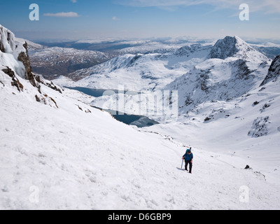 Snowdon in condizioni invernali - una femmina di hill walker heads up il Pyg via al vertice Foto Stock