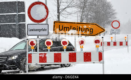 Un segno mette in guardia contro il pericolo di valanghe accanto a un segno di diversione a Mittenwald, Germania, 16 febbraio 2012. Foto: FRANK LEONHARDT Foto Stock