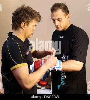 Boxing coach Dirk Dzemski cravatte i guanti della boxe Pro Francesco Pianeta (R) durante un breve training camp di organiser boxe Boxing SES nel Mar Baltico località balneare Dierhagen, Germania, 12 aprile 2013. Foto: Bernd Wuestneck Foto Stock