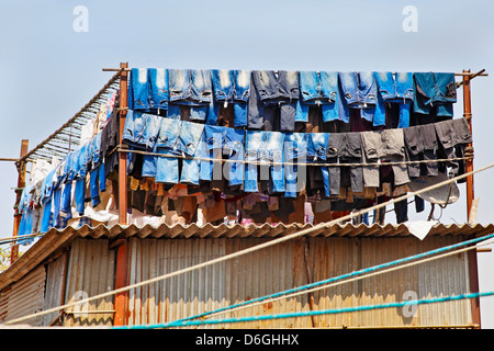 Jeans Denim lavato e appesa ad asciugare in metà giornata sole in corrispondenza di un lavaggio commerciale di fabbrica. Posizione di tiro di Bombay in India Foto Stock