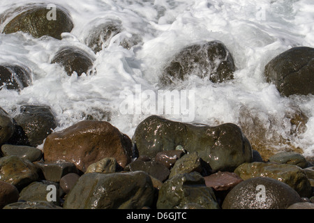 Onde che si infrangono sulle rocce Foto Stock