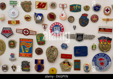 Scudetti e insignias dalla RDT sono sul display nella nuova esposizione permanente al Dokumentationszentrum Alltagskultur der DDR (Centro di Documentazione della cultura quotidiana della RDT) in Eisenhuettenstadt, Germania, 22 febbraio 2012. La mostra "La vita quotidiana: GDR' ('Alltag: DDR') è aperto dal 25 febbraio 2012 con oggetti, interviste e filmati sulla vita quotidiana in Oriente Ge Foto Stock