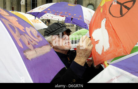 (Dpa-file) - Un file immagine datata 12 ottobre 2007 Mostra artista Matt Agnello firma colorfully ombrelli dipinti a Berlino, Germania. Agnello, che è diventato famoso per il suo progetto "l agnello ombrelloni per la pace", morì all età di 79 anni in Chicago, a causa di una malattia polmonare, secondo le dichiarazioni di sua figlia per il "Chicago Sun Times' il 21 febbraio 2012. Foto: Soeren Stache Foto Stock