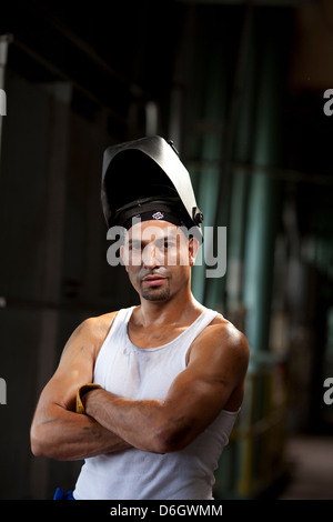 Operaio industriale nel casco per saldatura Foto Stock