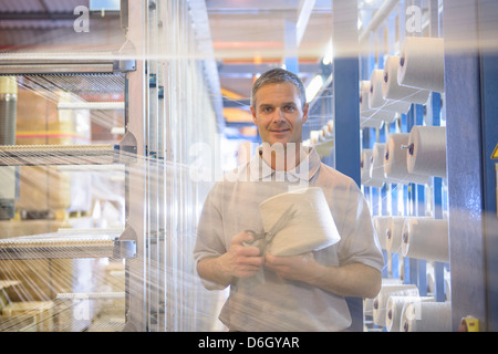 Azienda worker thread nel mulino tessile Foto Stock