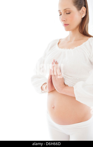 Donna incinta a praticare yoga Foto Stock