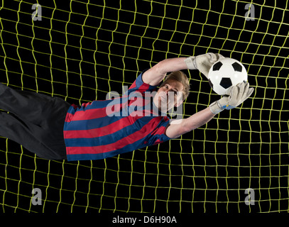 Giocatore di calcio la cattura di palla in aria Foto Stock