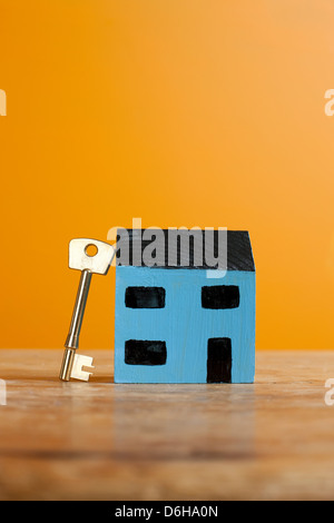 La chiave appoggiata sul modello di casa Foto Stock