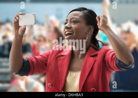 La donna a stadium, registrazione evento con il suo telefono Foto Stock