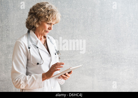Medico donna utilizzando a tavoletta digitale Foto Stock