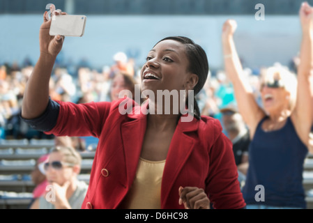 La donna a stadium, registrazione evento con il suo telefono Foto Stock