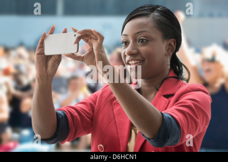 La donna a stadium, registrazione evento con il suo telefono Foto Stock