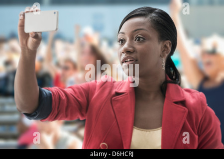 La donna a stadium, registrazione evento con il suo telefono Foto Stock