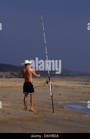 Surf fisherman controllando la sua verga sul Nord Padre Island Texas Foto Stock