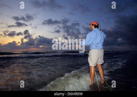 Un pescatore di pesca a mosca nel surf dalla spiaggia di sunrise per scorfano di Norvegia a New Smyrna Florida Foto Stock