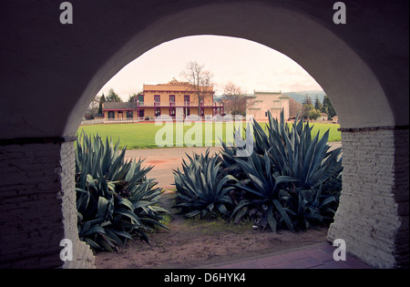 Vista la storica plaza hall e il cortile da un arco in San Juan Bautista Mission di Monterey County USA Foto Stock