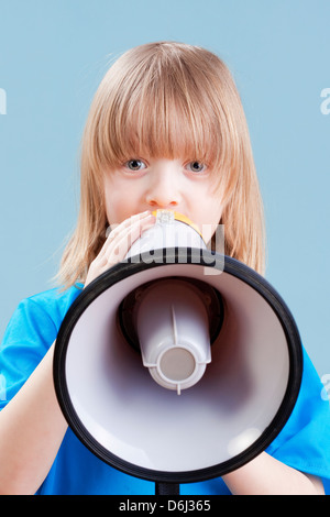 Ragazzo con capelli lunghi biondi giocando con il megafono - isolato su blu Foto Stock