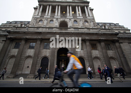 Un ciclista cavalca una Boris Bike sponsorizzata da Barclays passando davanti alla storica Bank of England su Threadneedle Street nella City di Londra, una scena che unisce la mobilità moderna al patrimonio finanziario britannico Foto Stock