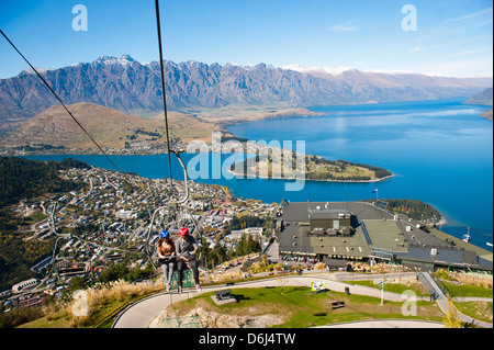 Due turisti in gondola per la pista di slittino sopra Queenstown, Otago, South Island, in Nuova Zelanda, Pacific Foto Stock