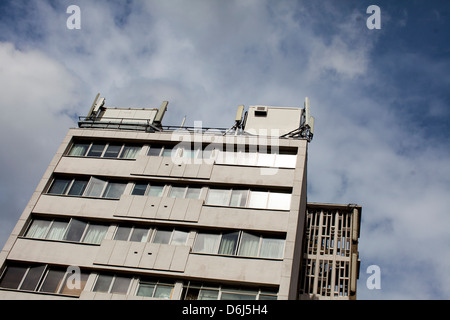 Antenne per telefonia mobile su un blocco di uffici a Londra, Inghilterra contro un cielo nuvoloso. Foto Stock