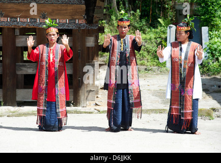 Tre Batak tribeswomen in costume tribale di eseguire la tradizionale danza, Huta Bolon, Simanindo, Sumatra, Indonesia Foto Stock