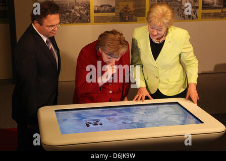 Ministro tedesco degli Interni Hans-Peter Friedrich (CSU, L-R), il Cancelliere tedesco Angela Merkel e il Presidente della Federazione dei profughi (BDV) Erika Steinbach prendere parte al ricevimento annuale della Federazione dei profughi e l'apertura della mostra "HeimatWEH' e guardare una mappa interattiva di Berlino, Germania, 20 marzo 2012. Foto: Wolfgang Kumm Foto Stock