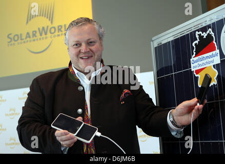 Amministratore Delegato della società fotovoltaico Solarworld AG, Frank Asbeck, presenta un caricabatterie ad energia solare per un iphone all'inizio di un briefing con la stampa sui risultati annuali a Bonn, Germania, 22 marzo 2012. Solarworld vuole tornare ad operare in nero nel 2012. Foto: OLIVER BERG Foto Stock