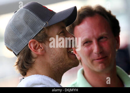 Tedesco di Formula Uno pilota Sebastian Vettel della Red Bull (anteriore) parla con il team principal della Red Bull, British Christian Horner, nella sua teamgarage sul circuito di Sepang, al di fuori di Kuala Lumpur, Malesia, 22 marzo 2012. Il Gran Premio di Formula Uno di Malesia avrà luogo il 25 marzo 2012. Foto: Jens Buettner Foto Stock