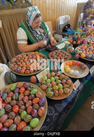 Kerstin Hanusch, indossando un sorabo costume tradizionale, è uno dei 30 partecipanti del xv sorabo Uovo di Pasqua nel mercato Schleife, Germania, 24 marzo 2012. Le quattro tecniche di progettazione di uova di Pasqua - wa-batik, cera-goffratura, graffiatura e attacco - vengono presentati al pubblico fino al 25 marzo 2012. Foto: MATTHIAS HIEKEL Foto Stock