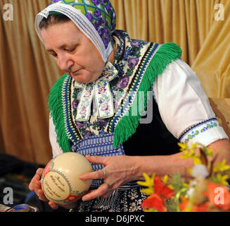 Petra Nakoinz, indossando un sorabo costume tradizionale, è uno dei 30 partecipanti del xv sorabo Uovo di Pasqua nel mercato Schleife, Germania, 24 marzo 2012. Le quattro tecniche di progettazione di uova di Pasqua - wa-batik, cera-goffratura, graffiatura e attacco - vengono presentati al pubblico fino al 25 marzo 2012. Foto: MATTHIAS HIEKEL Foto Stock