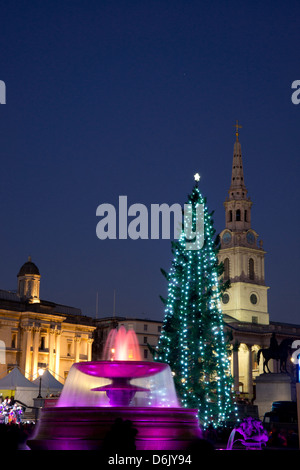 Un albero di Natale e le fontane illuminate per un concerto di Natale a Trafalgar Square a Londra, Inghilterra, Regno Unito, Europa Foto Stock