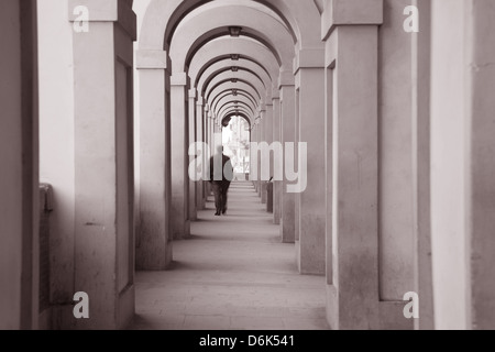 Corridoio Vasariano passaggio, Firenze, Italia con sfocato uomo a camminare nella distanza in bianco e nero tonalità seppia Foto Stock