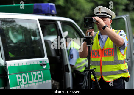 Un funzionario di polizia misura la velocità delle vetture con una velocità del laser gun a Duesseldorf in Germania, 29 giugno 2012. Il 03 luglio 2012 la polizia potrà effettuare la sua seconda velocità maratona di controllo. I cittadini del Land Renania settentrionale-Vestfalia sono stati coinvolti nella decisione dove impostare i comandi della velocità. Foto: Marius Becker Foto Stock