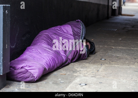 Senzatetto sonno agitato in un sacco a pelo, Londra, Inghilterra, Regno Unito. Foto Stock