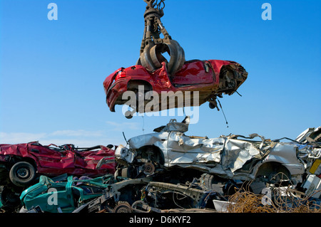 Gru di prelevare un auto in un junkyard Foto Stock