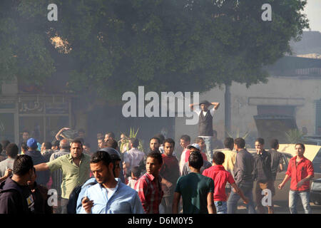 Il Cairo, Egitto. 19 Aprile, 2013. Governo anti-manifestanti si radunano attorno a un bus di masterizzazione appartiene alla Fratellanza Musulmana dopo anti-Presidente Mohammed Morsi dimostranti impostare il fuoco durante scontri nei pressi di Piazza Tahrir a Il Cairo, 19 aprile 2013 (immagine di credito: credito: Tareq Gabas APA/images/ZUMAPRESS.com/Alamy Live News) Foto Stock