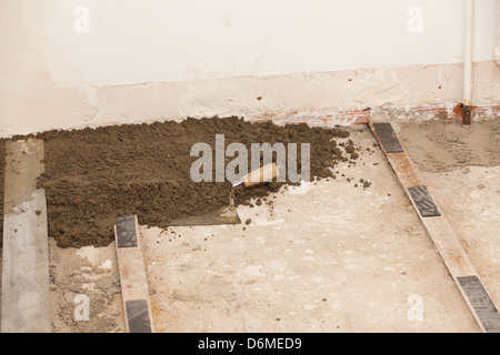 Realizzazione di un massetto di cemento in una casa Foto Stock