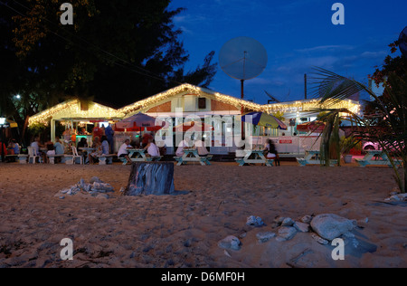 Holetown, Barbados, gli ospiti siedono la sera prima gli illuminati Surfside Ristorante Foto Stock