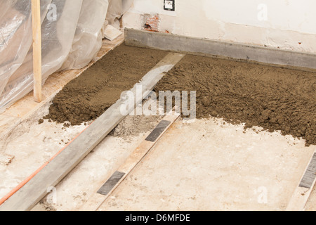 Realizzazione di un massetto di cemento in una casa Foto Stock