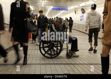 Hong Kong, Cina, mendicante si siede nella sua sedia a rotelle in un Fussgaengertunnel Foto Stock