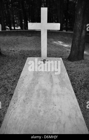 Croce e la tomba di marmo pietra tombale tra alberi. Foto Stock